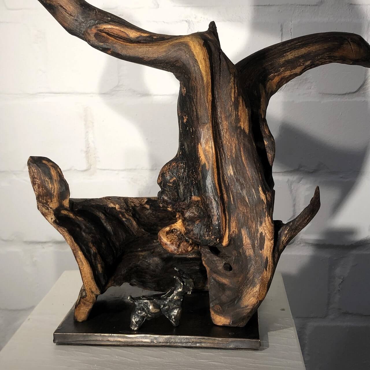 Ziegenkopf aus Holz mit Bronzeziege.